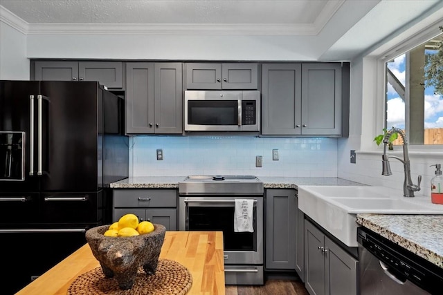 8307 Parasol Ln, Houston, TX 77064 - kitchen with appliances with stainless steel finishes, gray cabinetry, a sink, ornamental molding, and dark wood-style floors