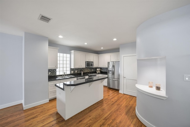 5810 Darling St Unit B, Houston, TX 77007 - kitchen with appliances with stainless steel finishes, a sink, backsplash, white cabinetry, and recessed lighting