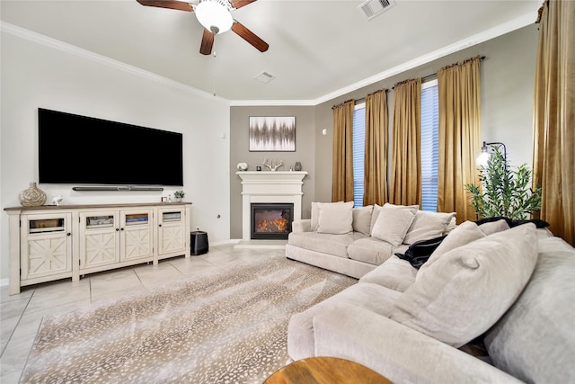 7411 Nottington Ct, Spring, TX 77379 - living room with light tile patterned flooring, a ceiling fan, crown molding, and a glass covered fireplace