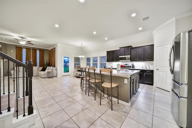 7411 Nottington Ct, Spring, TX 77379 - kitchen featuring stainless steel appliances, ornamental molding, light tile patterned flooring, a breakfast bar area, and a kitchen island with sink
