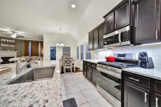 7411 Nottington Ct, Spring, TX 77379 - kitchen with stainless steel appliances, lofted ceiling, decorative backsplash, ceiling fan, and open floor plan
