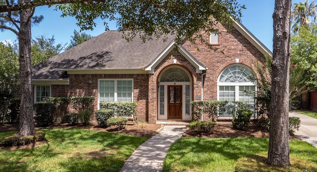 2107 Enchanted Lake Dr, League City, TX 77573 - view of front facade with brick siding, roof with shingles, and a front lawn