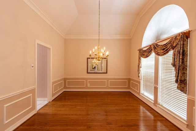 2107 Enchanted Lake Dr, League City, TX 77573 - unfurnished dining area with a chandelier, vaulted ceiling, wood finished floors, crown molding, and wainscoting