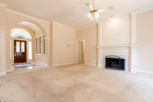 2107 Enchanted Lake Dr, League City, TX 77573 - unfurnished living room with ceiling fan, light colored carpet, arched walkways, a fireplace, and crown molding