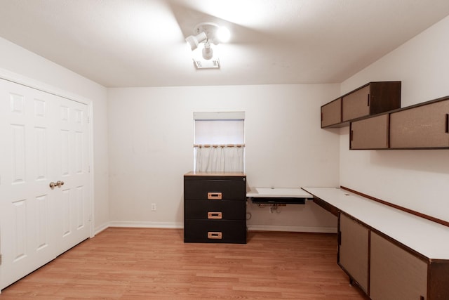 2107 Enchanted Lake Dr, League City, TX 77573 - unfurnished office featuring light wood-type flooring, built in desk, and baseboards