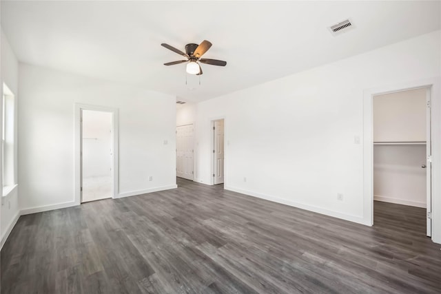 5608 Hollow Pines Dr, Houston, TX 77049 - unfurnished bedroom featuring dark wood finished floors, baseboards, a walk in closet, ceiling fan, and connected bathroom