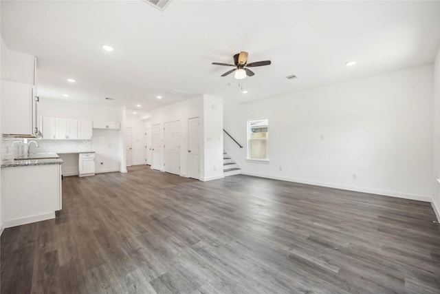 5608 Hollow Pines Dr, Houston, TX 77049 - unfurnished living room featuring ceiling fan, recessed lighting, stairs, and dark wood-style floors