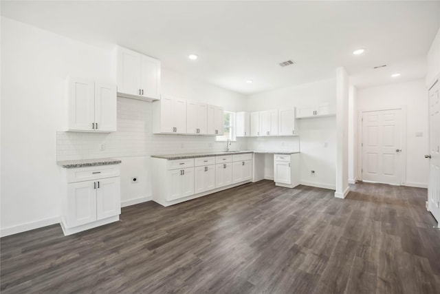 5608 Hollow Pines Dr, Houston, TX 77049 - kitchen with white cabinets, dark wood-style floors, tasteful backsplash, and recessed lighting