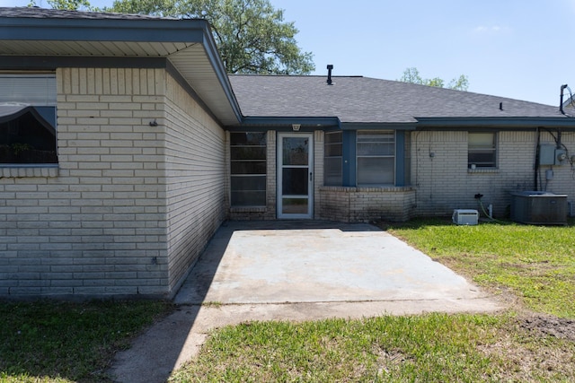 702 Meadowglen Dr, Baytown, TX 77521 - back of house featuring a patio, brick siding, a shingled roof, and a lawn