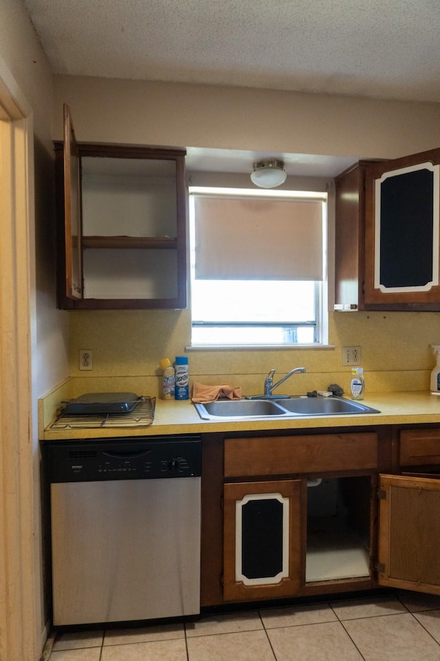 702 Meadowglen Dr, Baytown, TX 77521 - kitchen with dishwasher, light countertops, light tile patterned floors, and brown cabinets