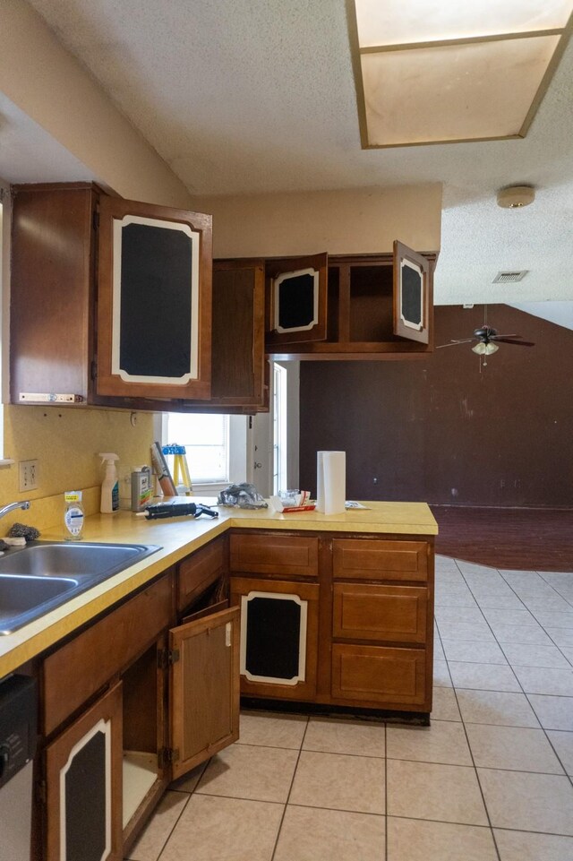 702 Meadowglen Dr, Baytown, TX 77521 - kitchen featuring light countertops, a textured ceiling, light tile patterned floors, dishwashing machine, and a ceiling fan