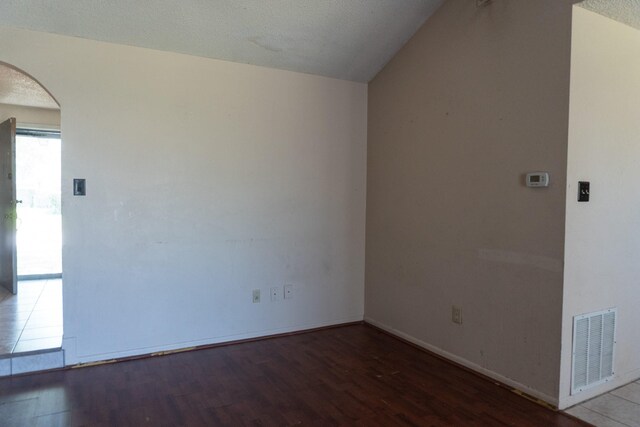 702 Meadowglen Dr, Baytown, TX 77521 - unfurnished room featuring arched walkways, wood finished floors, and lofted ceiling