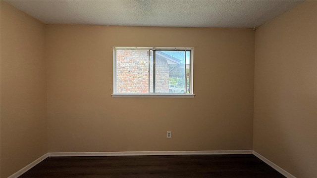 702 Meadowglen Dr, Baytown, TX 77521 - spare room featuring dark wood finished floors and a textured ceiling