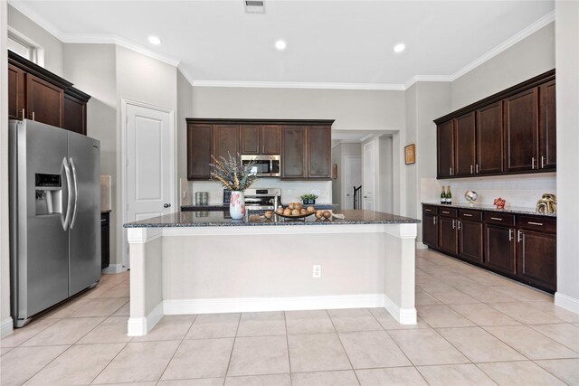 3507 Canyon Branch Ln, Fulshear, TX 77441 - kitchen with stainless steel appliances, dark stone counters, crown molding, dark brown cabinets, and recessed lighting