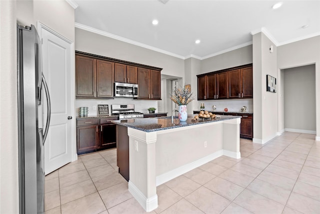 3507 Canyon Branch Ln, Fulshear, TX 77441 - kitchen featuring appliances with stainless steel finishes, dark stone counters, light tile patterned floors, a kitchen island with sink, and crown molding