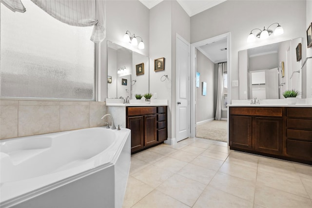 3507 Canyon Branch Ln, Fulshear, TX 77441 - bathroom featuring two vanities, a garden tub, ornamental molding, tile patterned floors, and baseboards