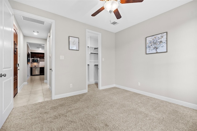 3507 Canyon Branch Ln, Fulshear, TX 77441 - unfurnished bedroom with light colored carpet, baseboards, a walk in closet, and a ceiling fan