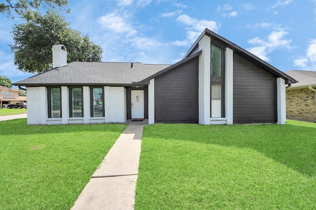 4203 Steep Rock Dr, Pasadena, TX 77504 - mid-century modern home featuring a front lawn, a chimney, and a shingled roof