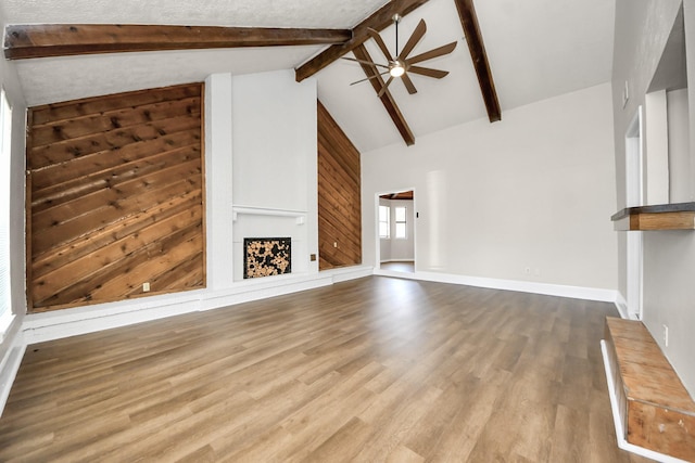 4203 Steep Rock Dr, Pasadena, TX 77504 - unfurnished living room with ceiling fan, a fireplace with raised hearth, beamed ceiling, wood finished floors, and high vaulted ceiling
