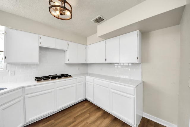 4203 Steep Rock Dr, Pasadena, TX 77504 - kitchen with gas cooktop, backsplash, dark wood-type flooring, white cabinets, and a textured ceiling