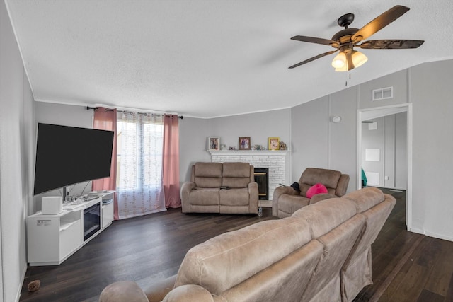 497 Rd 5603, Cleveland, TX 77327 - living room with a brick fireplace, dark wood-style floors, a ceiling fan, lofted ceiling, and a textured ceiling