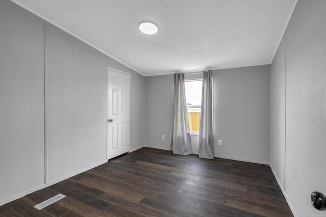 497 Rd 5603, Cleveland, TX 77327 - spare room with dark wood-type flooring, lofted ceiling, and baseboards