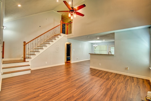 7022 Raven Cliffs Ln, Spring, TX 77379 - unfurnished living room featuring ceiling fan, wood finished floors, a chandelier, arched walkways, and crown molding