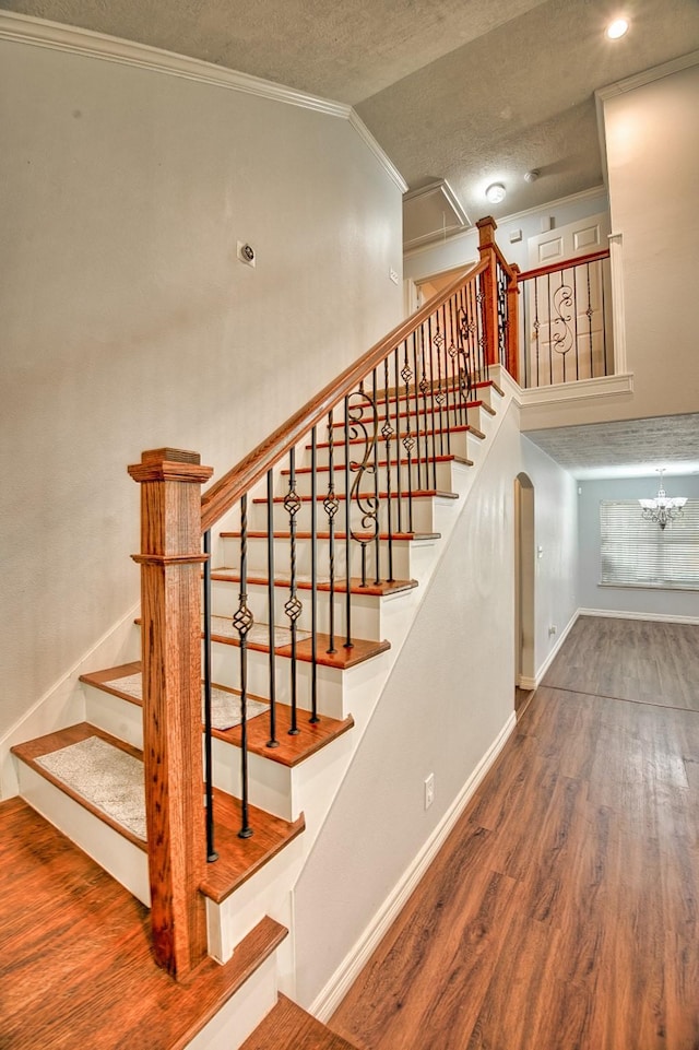 7022 Raven Cliffs Ln, Spring, TX 77379 - stairway featuring a textured ceiling, wood finished floors, ornamental molding, vaulted ceiling, and arched walkways