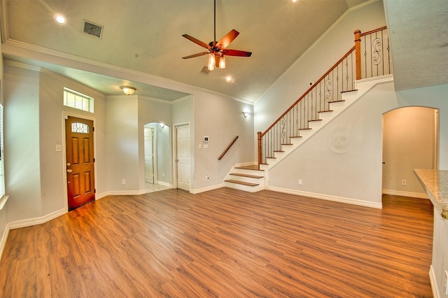 7022 Raven Cliffs Ln, Spring, TX 77379 - foyer featuring arched walkways, stairway, crown molding, ceiling fan, and wood finished floors