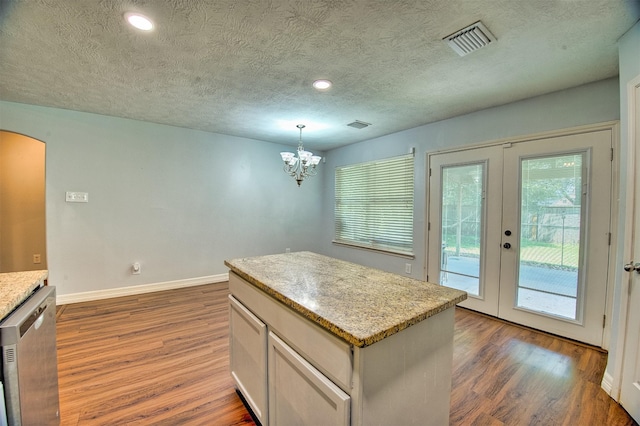 7022 Raven Cliffs Ln, Spring, TX 77379 - kitchen with wood finished floors, dishwasher, a textured ceiling, arched walkways, and french doors