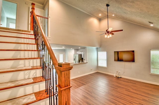 7022 Raven Cliffs Ln, Spring, TX 77379 - stairway with ornamental molding, wood finished floors, ceiling fan, plenty of natural light, and a textured ceiling