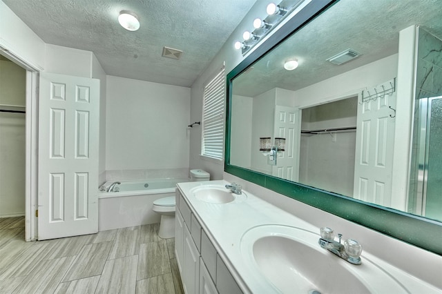 7022 Raven Cliffs Ln, Spring, TX 77379 - full bath featuring a bath, a walk in closet, double vanity, a textured ceiling, and a shower with door