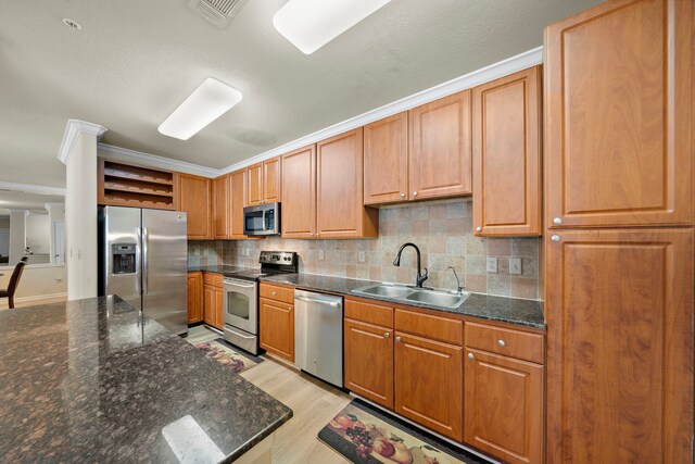 1711 Old Spanish Trl Unit 218, Houston, TX 77054 - kitchen with appliances with stainless steel finishes, a sink, open shelves, light wood finished floors, and decorative backsplash