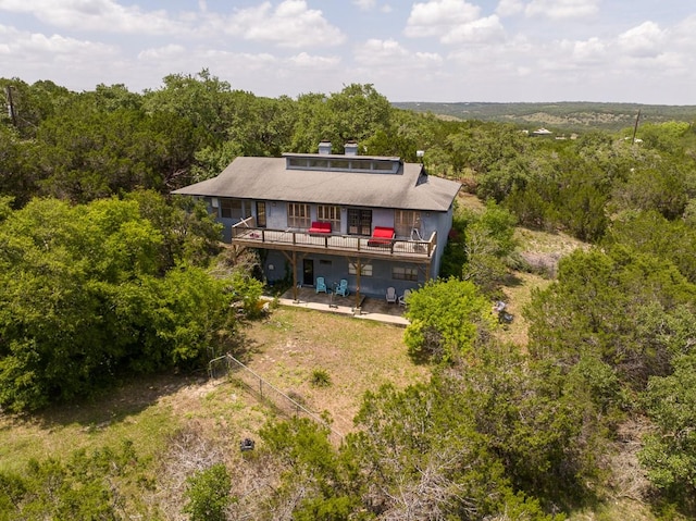 760 Skyline Rdg, Lookout, Wimberley, TX 78676 - back of house featuring a wooden deck, a patio area, a wooded view, and a chimney