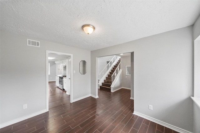 2251 Middle Creek Dr, Houston, TX 77339 - empty room featuring baseboards, stairway, dark wood-type flooring, and a textured ceiling