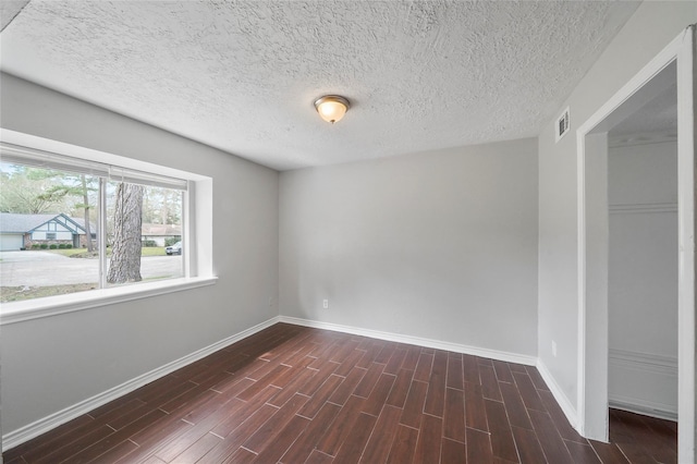 2251 Middle Creek Dr, Houston, TX 77339 - empty room featuring baseboards, dark wood-type flooring, and a textured ceiling