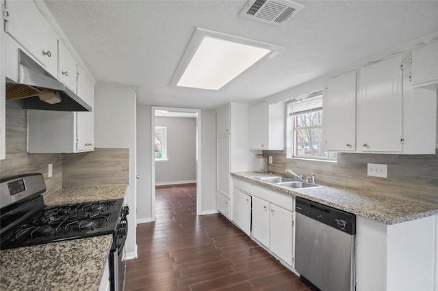 2251 Middle Creek Dr, Houston, TX 77339 - kitchen with appliances with stainless steel finishes, a sink, under cabinet range hood, decorative backsplash, and white cabinetry