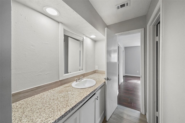 2251 Middle Creek Dr, Houston, TX 77339 - bathroom with wood finished floors, vanity, a textured wall, and baseboards