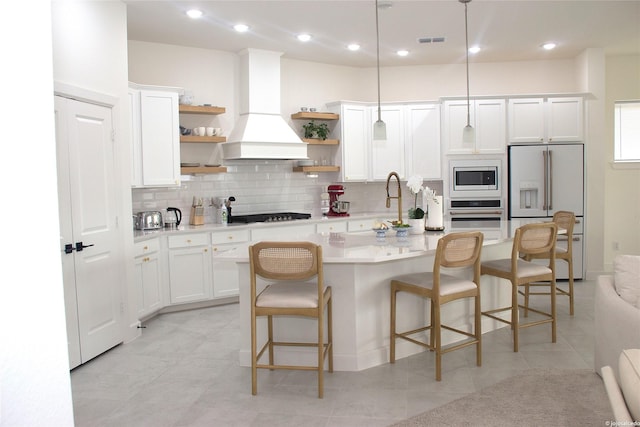 5619 Water Lilies Cor, Manvel, TX 77578 - kitchen with open shelves, white fridge with ice dispenser, built in microwave, oven, and premium range hood