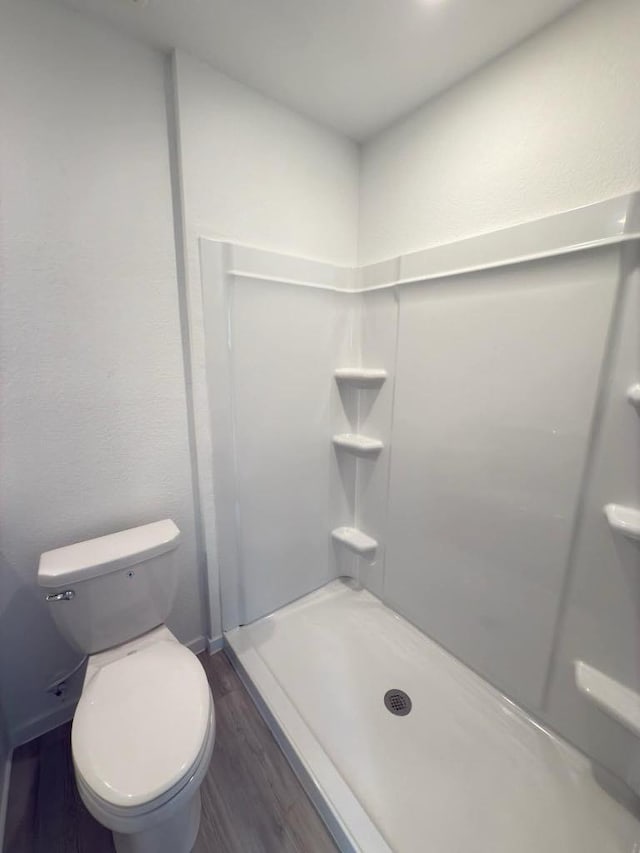 21026 Newberry Grove Ln, Humble, TX 77338 - bathroom featuring wood finished floors, a stall shower, and toilet