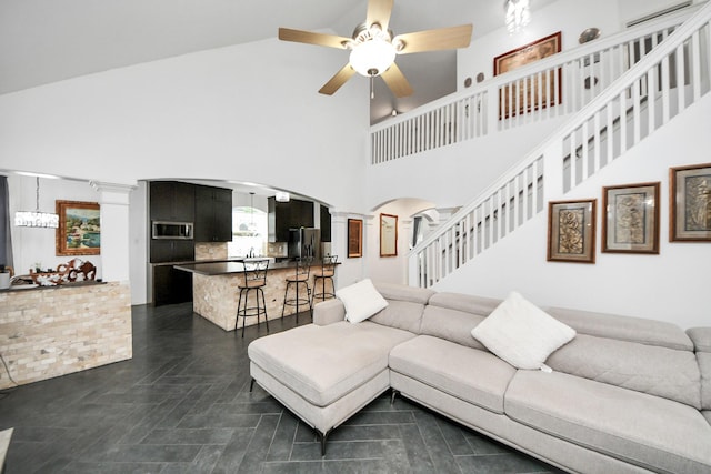 7410 Lassiter Hollow Ln, Richmond, TX 77407 - living room featuring arched walkways, ornate columns, a ceiling fan, a high ceiling, and stairway