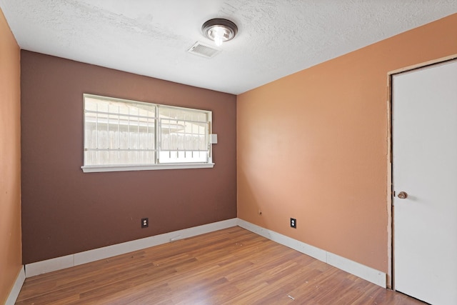 1318 Epsilon St, Pasadena, TX 77504 - empty room with wood finished floors, a textured ceiling, and baseboards