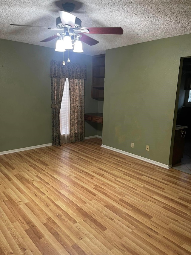 2724 22nd Ave N, Texas City, TX 77590 - unfurnished room featuring ceiling fan, wood finished floors, a textured ceiling, and baseboards