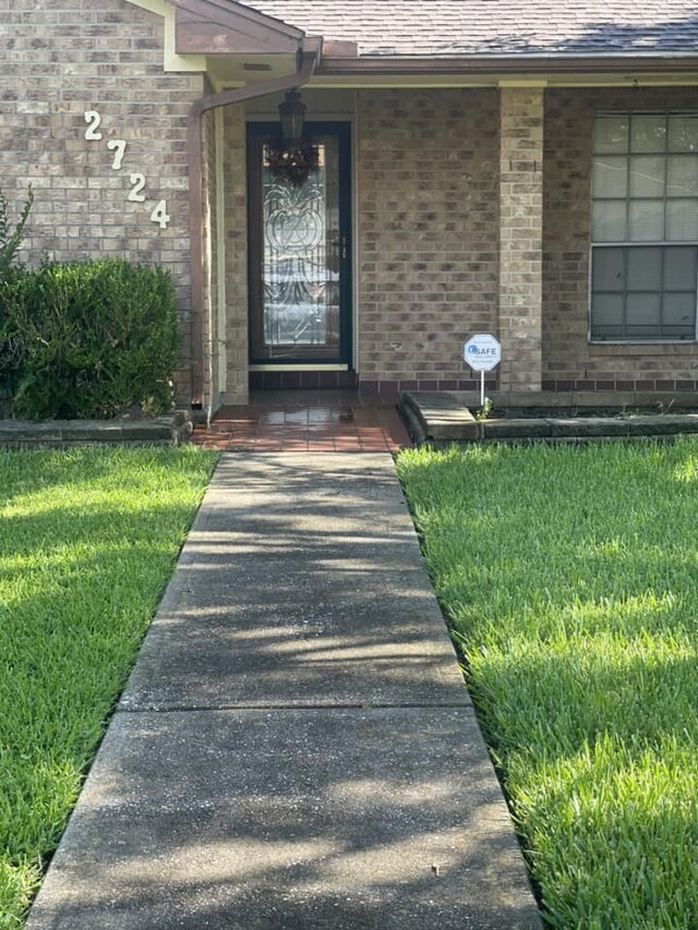 2724 22nd Ave N, Texas City, TX 77590 - property entrance featuring brick siding, a lawn, and a shingled roof