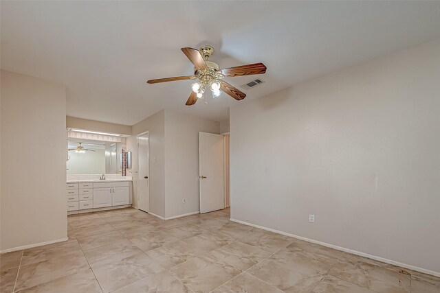 7650 Smiling Wood Ln, Houston, TX 77086 - unfurnished bedroom featuring baseboards, connected bathroom, and a ceiling fan