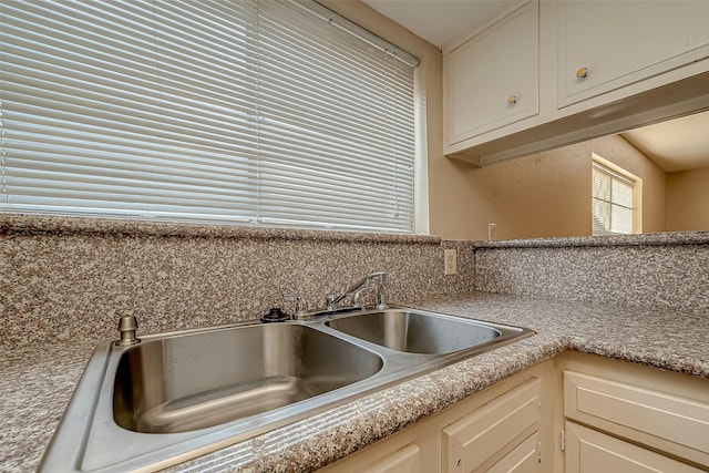 7650 Smiling Wood Ln, Houston, TX 77086 - kitchen featuring a sink, light countertops, and white cabinets