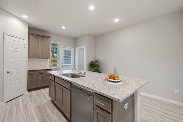 24708 Sonora Crescent Cir, Huffman, TX 77336 - kitchen featuring stainless steel dishwasher, a sink, light wood-style floors, a kitchen island with sink, and baseboards