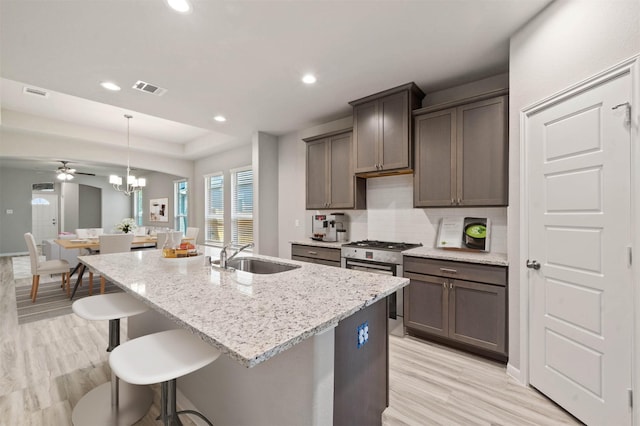 24708 Sonora Crescent Cir, Huffman, TX 77336 - kitchen featuring a sink, stainless steel range with gas cooktop, light stone counters, backsplash, and recessed lighting