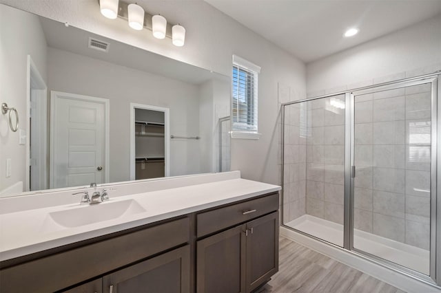 24708 Sonora Crescent Cir, Huffman, TX 77336 - bathroom featuring a stall shower, vanity, wood finished floors, a walk in closet, and recessed lighting