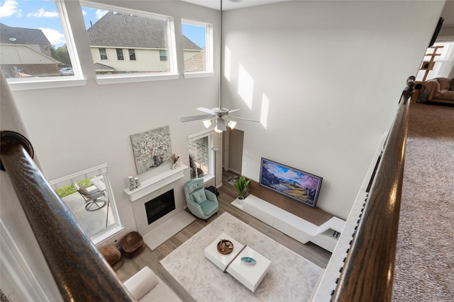 20714 Fertile Valley Ln, Richmond, TX 77407 - living area featuring a tile fireplace, a ceiling fan, and a towering ceiling